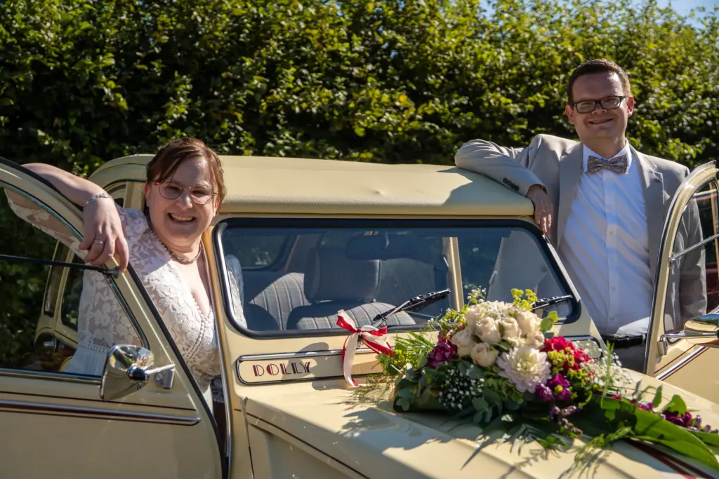 Hochzeitsfoto in Viersen – Brautpaar am Oldtimer mit Blumenschmuck