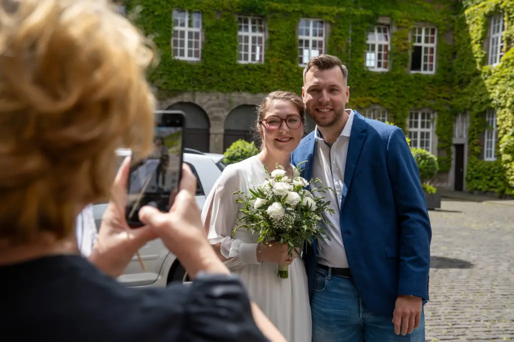 Hochzeitsfoto in Willich – Brautpaar vor Efeu‑Haus wird fotografiert