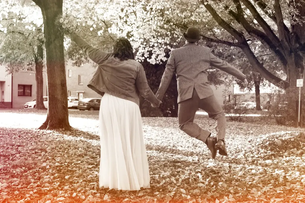 Hochzeitsfoto in Willich – Brautpaar im Herbst, fröhlicher Moment mit Sprung